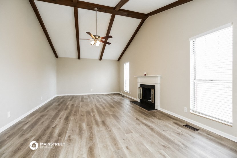 the living room with wood flooring and a fireplace