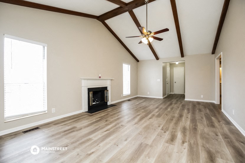 the living room of a new home with wood flooring and a fireplace