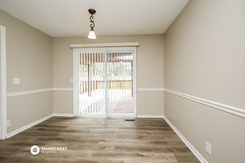 a spacious living room with a sliding glass door to a patio