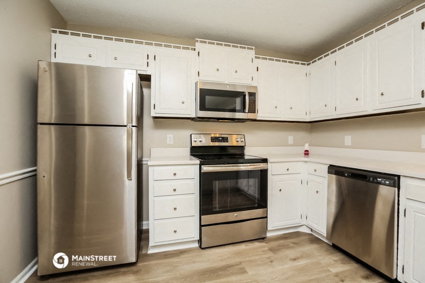 a white kitchen with stainless steel appliances and white cabinets