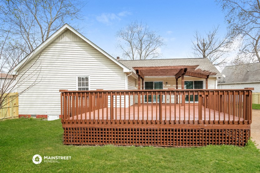 a deck with a house in the background