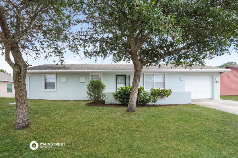 a white house with two trees in front of it