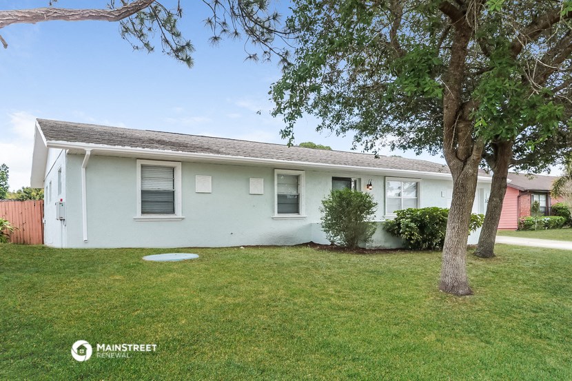 a white house with a yard and a tree