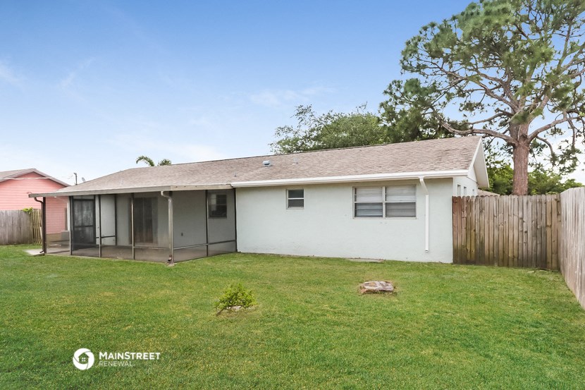a small white house with a yard and a fence