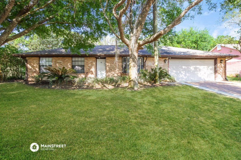 a small brick house with a tree in the yard