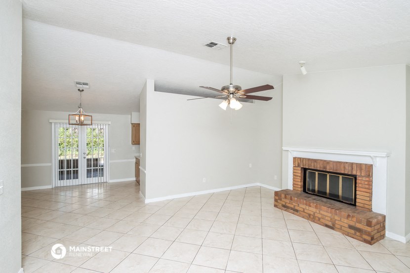 a living room with a fireplace and a ceiling fan