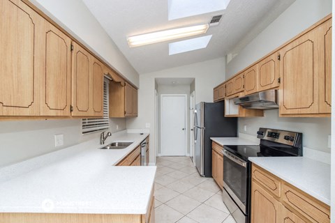 a large kitchen with wooden cabinets and white counter tops