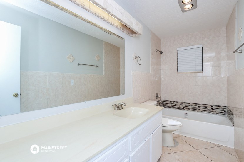 a bathroom with a large mirror and a toilet and a sink