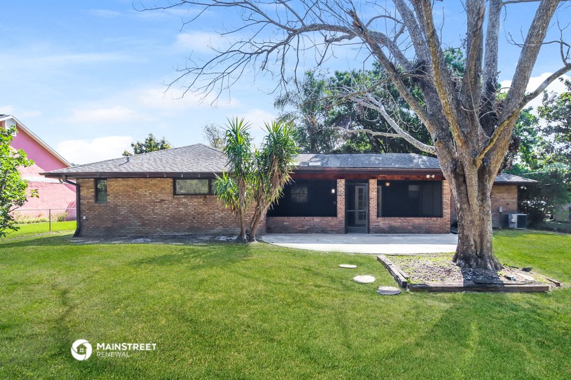 a brick house with a yard and a tree