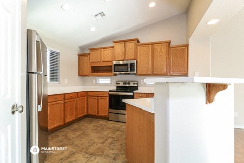 a kitchen with wooden cabinets and stainless steel appliances