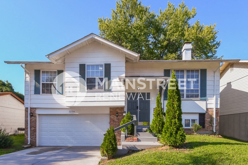 front view of a white house with a sign that reads nistwr wall