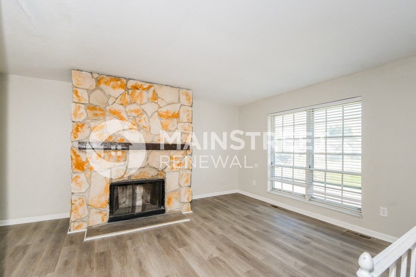 a living room with a fireplace and a large window
