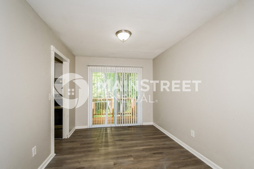 a living room with a door to a balcony and a window