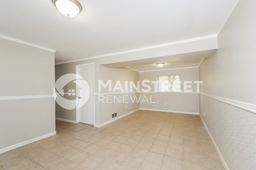 a renovated living room with a transition to a dining room