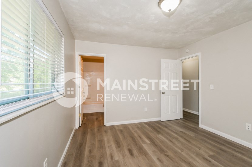 a bedroom apartment with a large window and a door