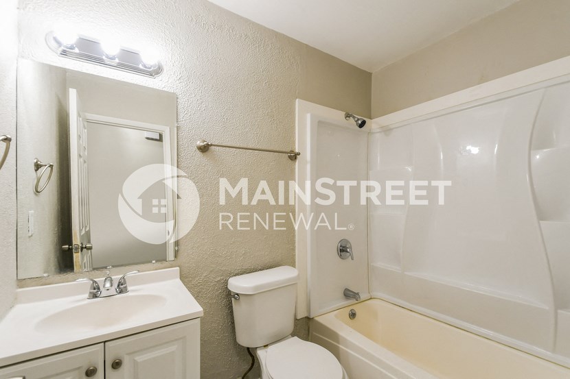 a small bathroom with a tub and a sink and a toilet