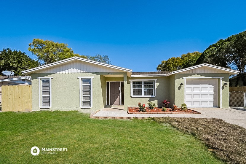 a yellow house with a lawn and a white garage door