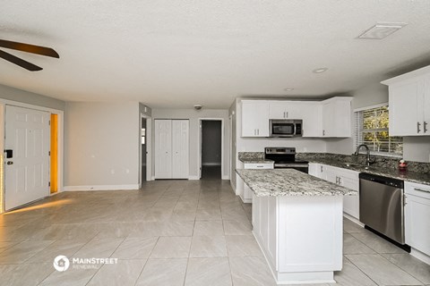 a large kitchen with white cabinets and granite counter tops