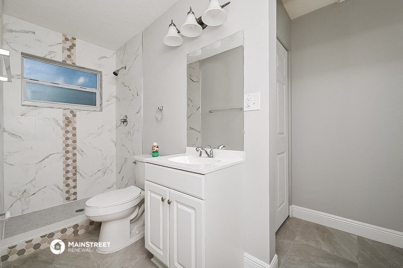 a bathroom with a sink toilet and a mirror
