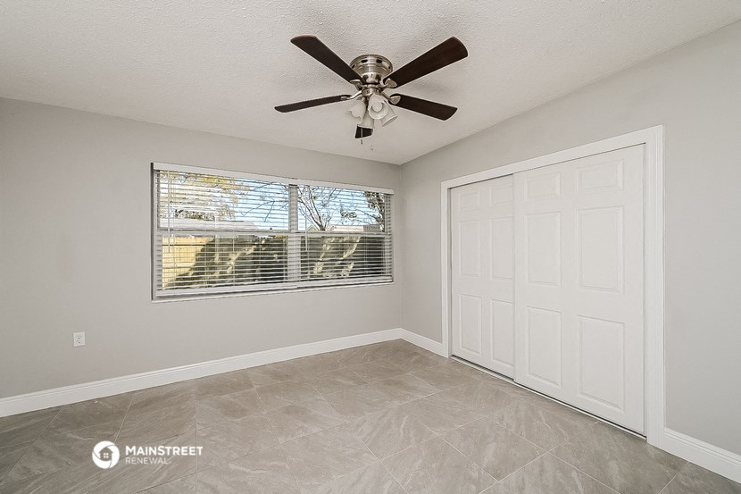 the living room has a large window and a ceiling fan