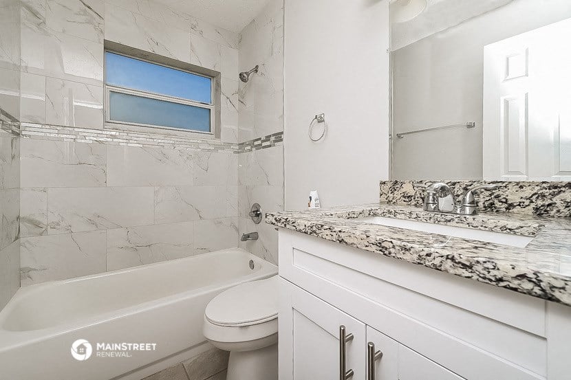 a white bathroom with a tub and a sink and a toilet