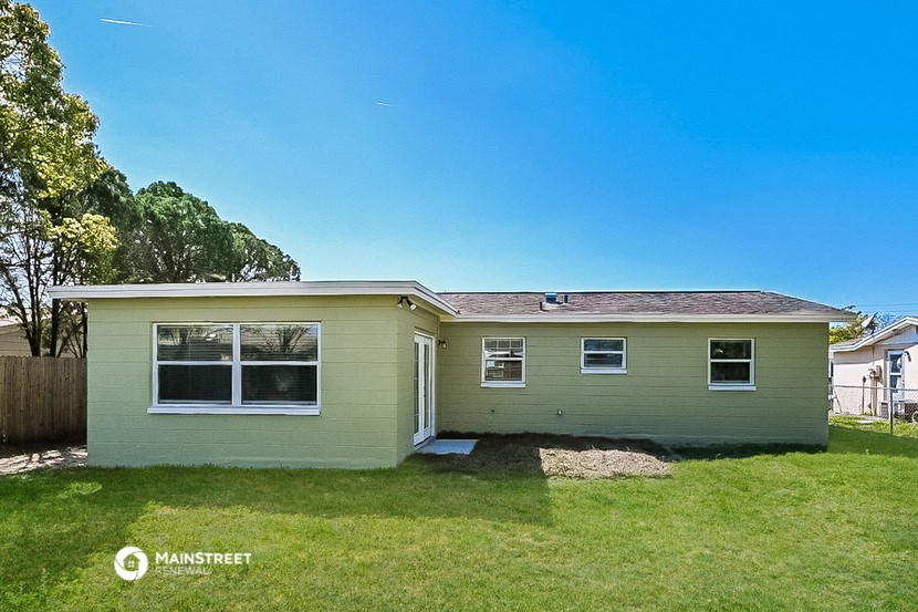 a green house with a lawn and a blue sky