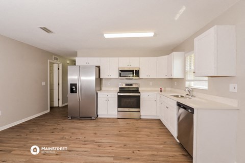 a white kitchen with stainless steel appliances and white cabinets