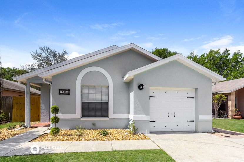a white house with a white garage door and a driveway