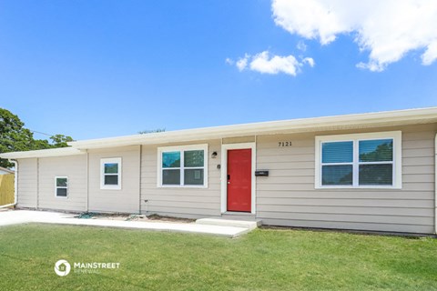a small white house with a red door
