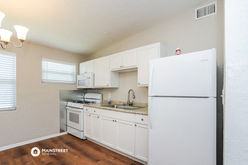 a kitchen with white cabinets and appliances and a white refrigerator