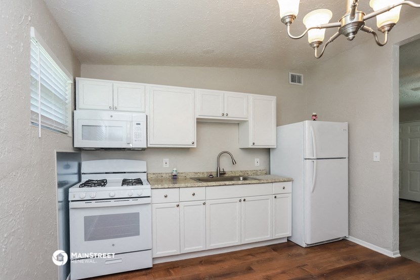 a kitchen with white appliances and a sink and a refrigerator