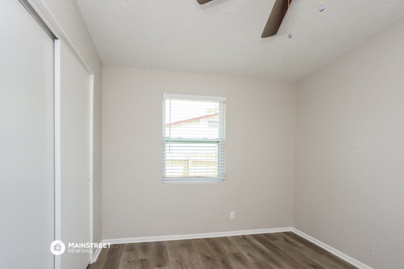 the living room of an apartment with white walls and a window