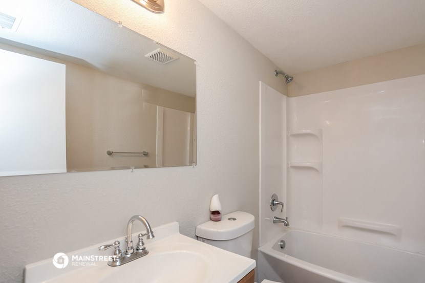 a bathroom with a sink and a tub and a mirror