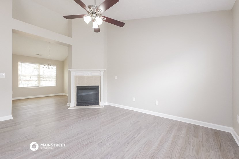 the living room with fireplace and ceiling fan