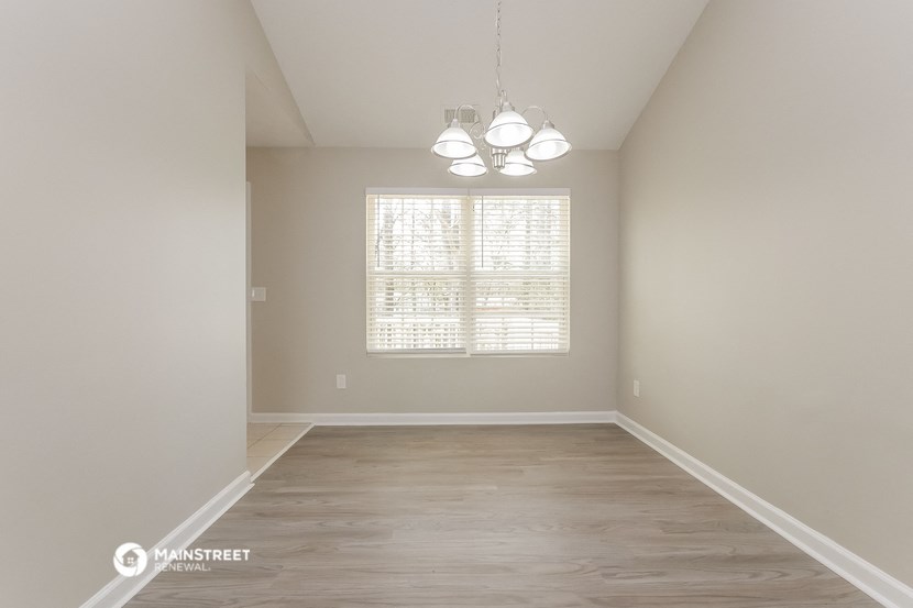 the spacious living room with hardwood flooring and a large window