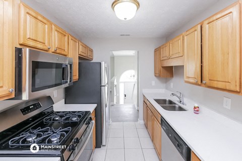 a kitchen with a stove and a sink and a refrigerator