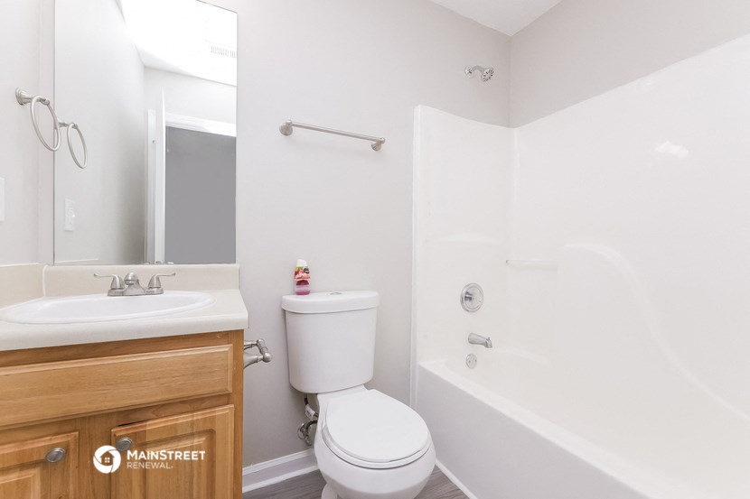 a bathroom with a toilet sink and tub and a mirror