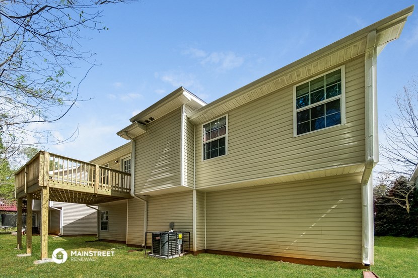 a yellow house with a deck on the side of it
