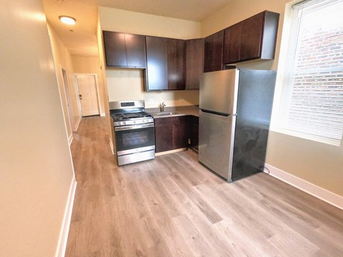 a kitchen with stainless steel appliances and wooden floors