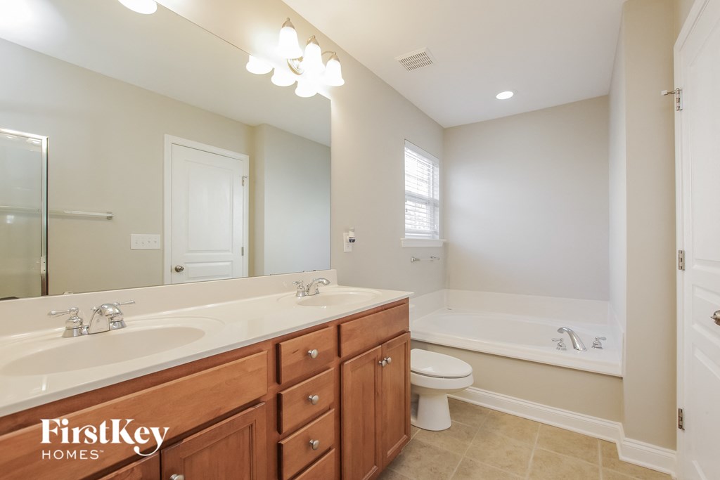 a bathroom with two sinks and a tub and a toilet