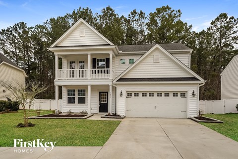 a white house with a white porch and a driveway