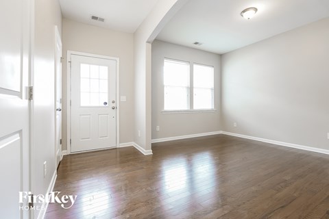 an empty living room with white walls and wood floors