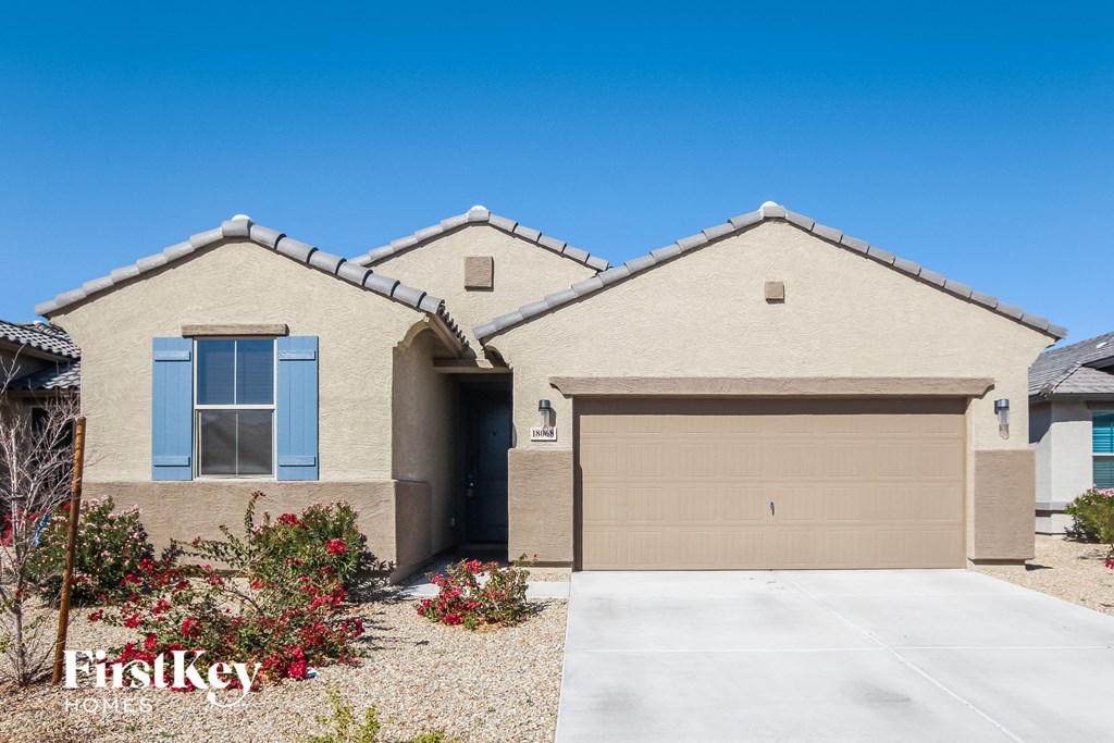 A beige house with a brown garage door and a blue window.