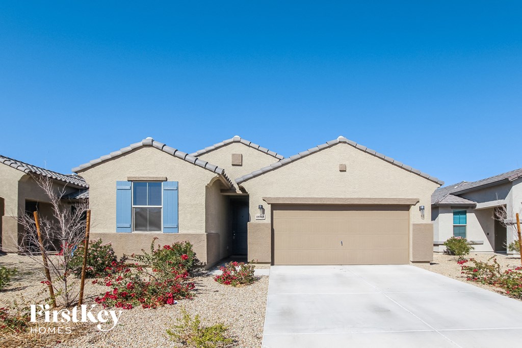 A house with a garage and a driveway in front of it.