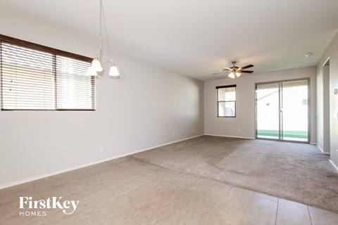 A spacious room with a carpeted floor and a ceiling fan.