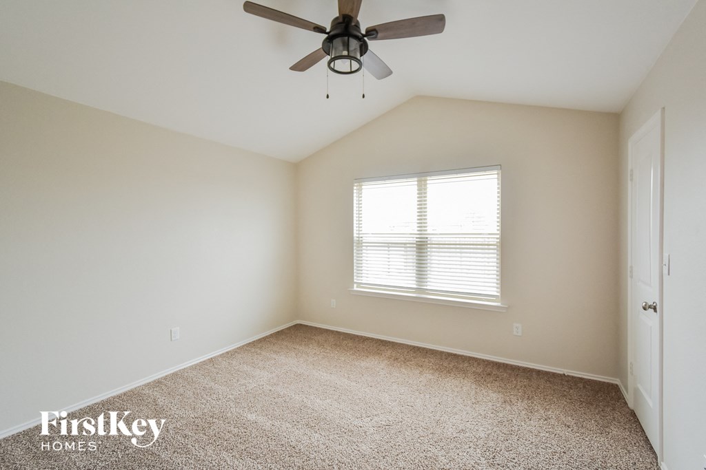 a bedroom with a ceiling fan and a window