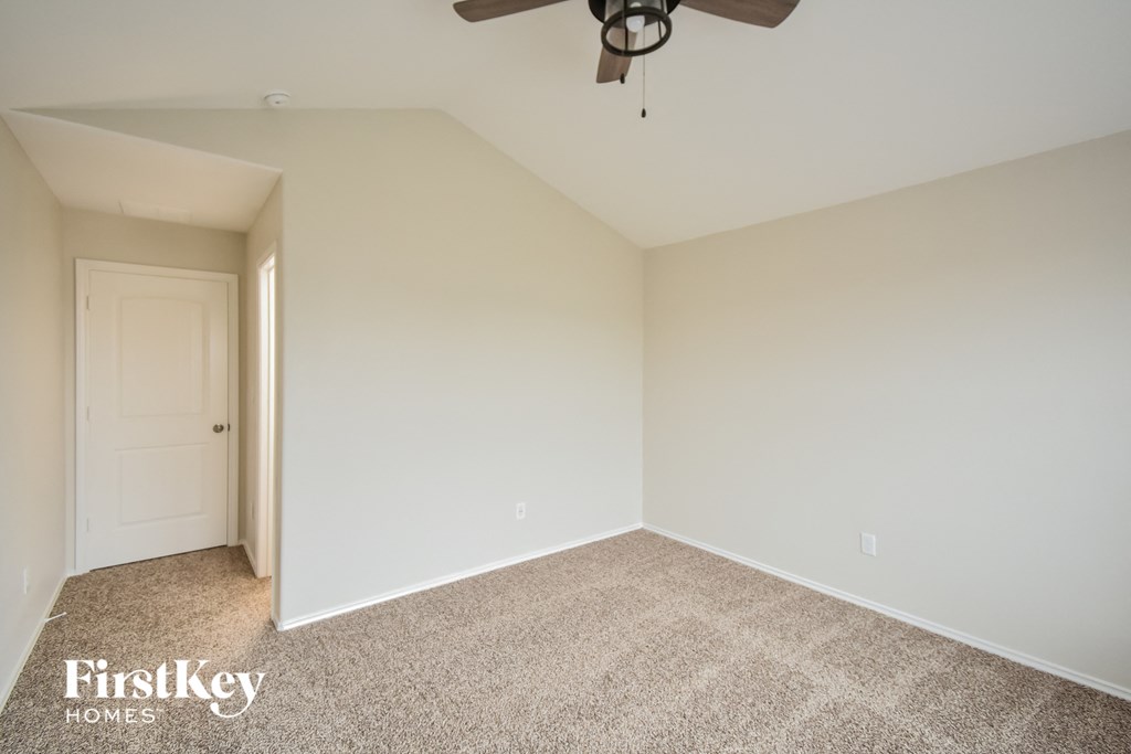 a empty room with a ceiling fan and a white door