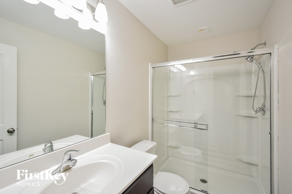 a bathroom with a shower and a sink and a mirror