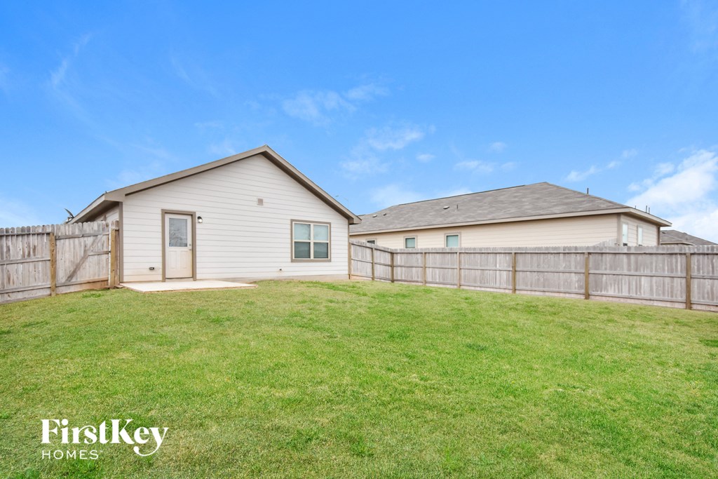 a backyard with a fence and two houses
