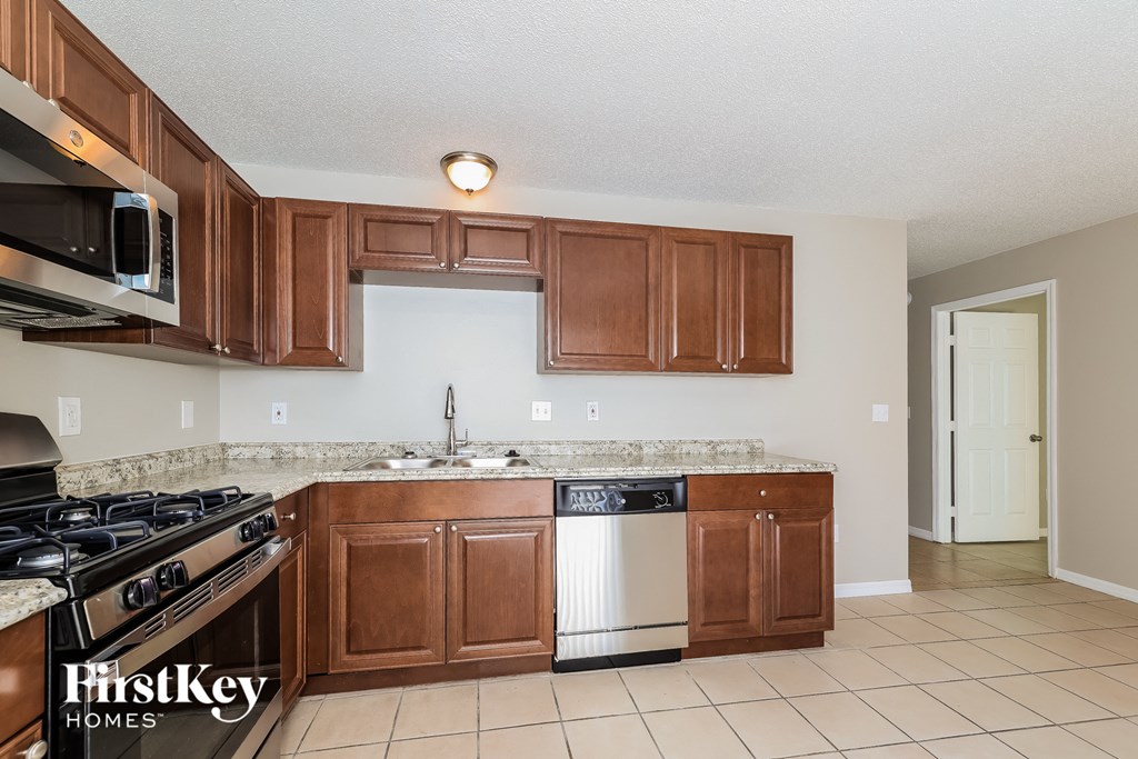 a kitchen with wooden cabinets and a stove and a sink